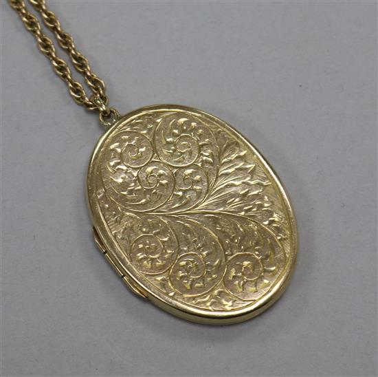 An engraved 9ct gold oval locket on a 9ct chain, locket 4cm.